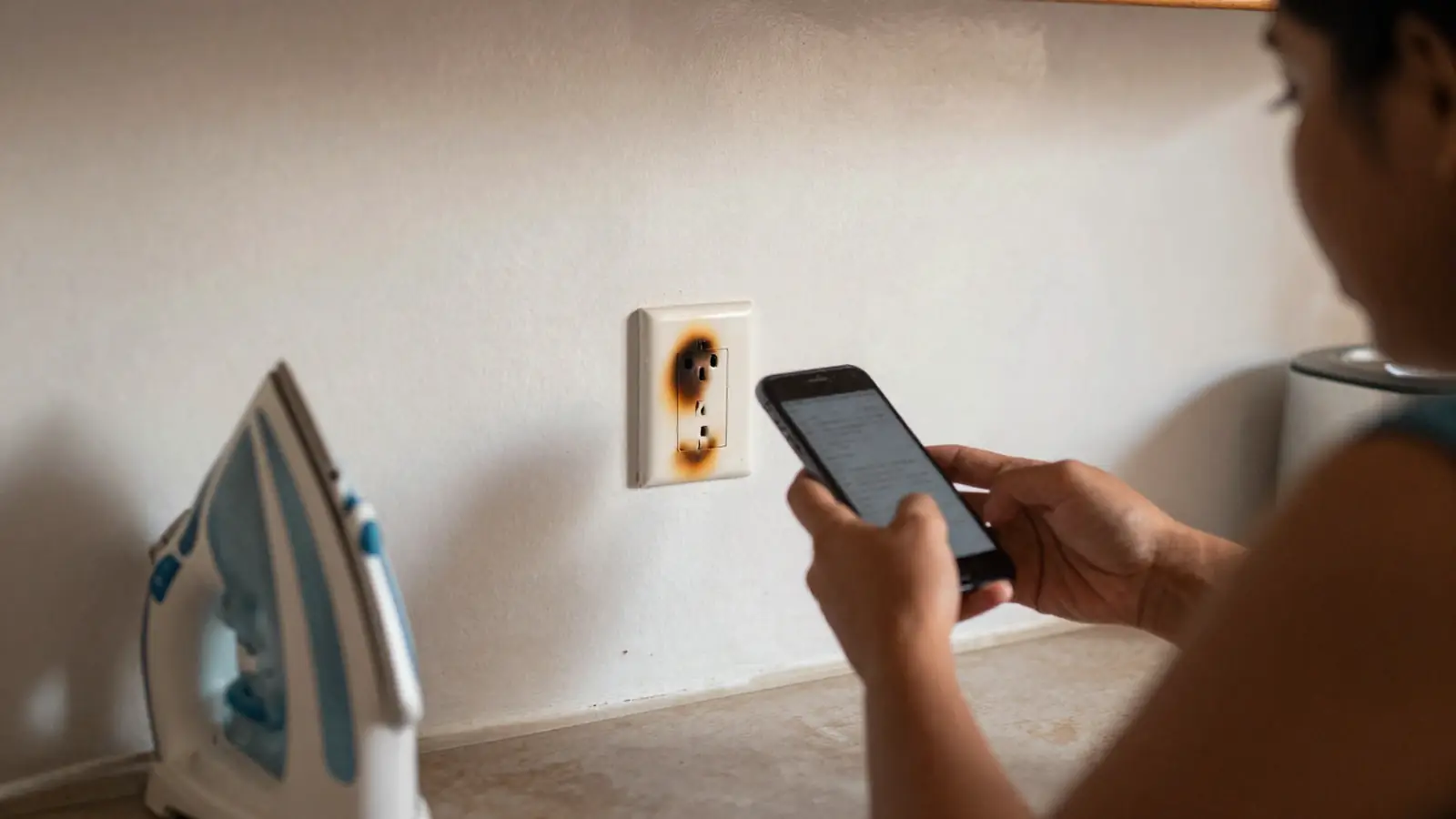 Clienta toma con el celular la foto de un contacto quemado en su cocina para mandársela al asistente de IA