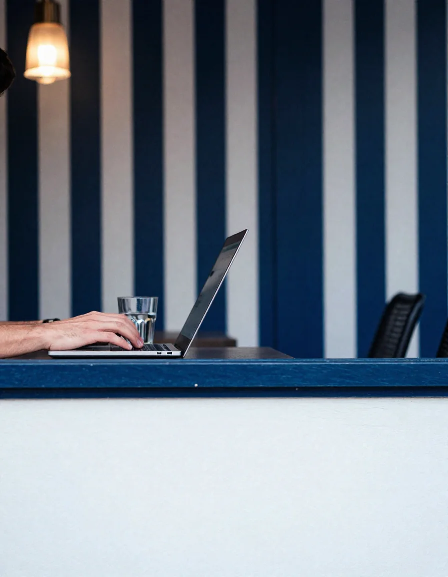 Manos escribiendo en una laptop.